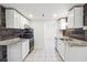 Well-lit kitchen with stainless steel appliances, granite countertops, and wood-look accent wall at 225 Bayswater Dr, Suwanee, GA 30024