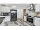 A modern kitchen featuring stainless steel appliances, granite countertops and stylish wood floors at 230 Woodward Se Ave, Atlanta, GA 30312
