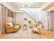 Bright living room with modern decor, featuring a comfortable sofa, stylish chairs, a staircase, and elegant light fixture at 230 Woodward Se Ave, Atlanta, GA 30312