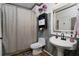 Bathroom with white fixtures, decorative accents, and a shower with patterned curtain at 3770 Falling Leaf Ln, Cumming, GA 30041