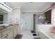 Bright bathroom with double sinks, marble tile, soaking tub, and glass-enclosed shower at 3770 Falling Leaf Ln, Cumming, GA 30041