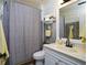 Cozy bathroom features patterned shower curtain, white vanity, and marble-look tile at 3770 Falling Leaf Ln, Cumming, GA 30041