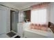 Bathroom features a soaking tub with a window, a glass-enclosed shower, and marble-style tile at 3770 Falling Leaf Ln, Cumming, GA 30041