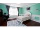 Mint bedroom boasts natural light, dark desk, and a comfortable bed, perfect for work or relaxation at 3770 Falling Leaf Ln, Cumming, GA 30041