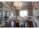 Dining room with a chandelier and wainscoting adjacent to a door and entranceway at 3770 Falling Leaf Ln, Cumming, GA 30041