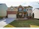 Two-story home with brick and siding exterior, well-manicured lawn, two-car garage, and decorative landscaping at 3770 Falling Leaf Ln, Cumming, GA 30041