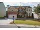 Two-story home with brick and siding exterior, manicured lawn, two-car garage, and attractive landscaping at 3770 Falling Leaf Ln, Cumming, GA 30041