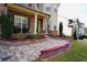 Close-up of brick-paved front porch with seating and lush landscaping detail at 3770 Falling Leaf Ln, Cumming, GA 30041