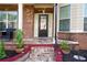 Close-up of brick-paved front porch with decorative columns and lush landscaping detail at 3770 Falling Leaf Ln, Cumming, GA 30041
