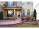 Close-up of brick-paved front porch with decorative columns, seating, and lush landscaping at 3770 Falling Leaf Ln, Cumming, GA 30041