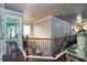Well-lit hallway features rich hardwood floors, wrought iron banister, and natural lighting at 3770 Falling Leaf Ln, Cumming, GA 30041