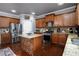 Kitchen features wood cabinets, granite countertops, stainless steel appliances, and an island with bar seating at 3770 Falling Leaf Ln, Cumming, GA 30041