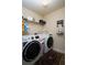 Well-organized laundry room with modern appliances, shelving, and cute decor accents at 3770 Falling Leaf Ln, Cumming, GA 30041