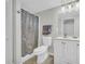 Cozy bathroom featuring a shower with striped curtain, white toilet, and a single vanity with light fixture at 582 Linda Ln, Powder Springs, GA 30127
