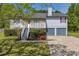 Inviting two-story house showcasing a cozy balcony, gray siding, a stone facade, and a convenient two-car garage at 582 Linda Ln, Powder Springs, GA 30127