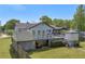 A view of the home's back exterior and raised porch, offering a private space for relaxing or entertaining at 582 Linda Ln, Powder Springs, GA 30127