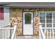 Close-up of the home's entrance with a stone facade, decorative door, and welcoming exterior lighting at 582 Linda Ln, Powder Springs, GA 30127