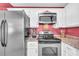 Sleek kitchen with stainless steel appliances and red accent wall, offering a stylish and efficient cooking space at 582 Linda Ln, Powder Springs, GA 30127