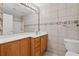 Bathroom featuring a wood vanity, large mirror, and tiled walls and floors at 795 Hammond Dr # 2101, Atlanta, GA 30328