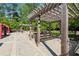 Community grilling area with modern grill under wooden pergola and concrete walkway at 795 Hammond Dr # 2101, Atlanta, GA 30328