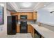 Functional kitchen featuring wood cabinets, black appliances, and neutral countertops at 795 Hammond Dr # 2101, Atlanta, GA 30328