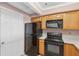 Functional kitchen featuring wood cabinets, black appliances, and neutral countertops at 795 Hammond Dr # 2101, Atlanta, GA 30328