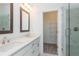 Bathroom featuring double sinks with white cabinets, a walk-in shower with marble walling, and shelving at 103 Iveybrooke Ln # 56, Alpharetta, GA 30009