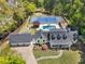 Stunning aerial view of estate featuring pool, tennis court, lush landscaping, and black shingle roof at 4440 Webb Bridge Rd, Alpharetta, GA 30005