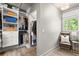 Organized walk-in closet with shelves and hanging rods for optimal storage, plus a seating area with a window at 4440 Webb Bridge Rd, Alpharetta, GA 30005