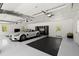 Well-lit garage with epoxy flooring, car, and storage cabinets at 4440 Webb Bridge Rd, Alpharetta, GA 30005