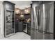 Modern kitchen features stainless steel appliances, a wine cooler, and stylish dark cabinetry at 4440 Webb Bridge Rd, Alpharetta, GA 30005