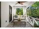 Inviting front porch with swing, seating, and views of the surrounding greenery at 4440 Webb Bridge Rd, Alpharetta, GA 30005