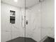 Modern shower with white marble-look tile and dark fixtures at 4440 Webb Bridge Rd, Alpharetta, GA 30005