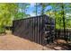 Secured black storage container in a wooded area, providing ample outdoor storage at 4440 Webb Bridge Rd, Alpharetta, GA 30005