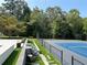 Backyard tennis court featuring sleek black fencing, stone retaining wall and outdoor seating at 4440 Webb Bridge Rd, Alpharetta, GA 30005