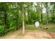 Wooded backyard featuring a storage shed and cozy fire pit area, perfect for outdoor entertaining at 57 Glenn Eagles Way, Hiram, GA 30141