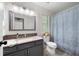 Well-lit bathroom featuring a vanity, granite countertop, and patterned shower curtain at 57 Glenn Eagles Way, Hiram, GA 30141
