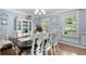 Cozy dining room featuring a dark wood table and chairs, complemented by natural light and pale blue walls at 57 Glenn Eagles Way, Hiram, GA 30141