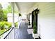 Inviting front porch features a swing, black railings, and a freshly painted floor at 57 Glenn Eagles Way, Hiram, GA 30141