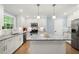 Modern kitchen features white cabinetry, stainless steel appliances, and a kitchen island with granite countertops at 57 Glenn Eagles Way, Hiram, GA 30141