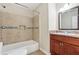 Well-lit bathroom featuring a tiled shower-tub, granite countertop vanity and matching tiles at 2895 Shurburne Dr, Alpharetta, GA 30022