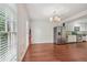 Open dining room with hardwood floors, two windows, and stainless steel refrigerator at 2895 Shurburne Dr, Alpharetta, GA 30022
