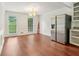 Open dining room with hardwood floors, two windows and stainless steel refrigerator at 2895 Shurburne Dr, Alpharetta, GA 30022
