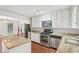 Modern kitchen with white cabinets, granite countertops, island and stainless steel appliances at 2895 Shurburne Dr, Alpharetta, GA 30022