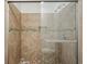 Neutral tiled shower with a decorative accent stripe, a recessed shelf, and a clear glass door at 2895 Shurburne Dr, Alpharetta, GA 30022