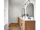 Bright bathroom with double vanity, wood cabinets, modern lighting, and a white bathtub at 3552 Clear Creek Nw Xing, Kennesaw, GA 30144