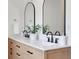 Bathroom featuring a double vanity with white countertops, modern faucets, and stylish arched mirrors at 3552 Clear Creek Nw Xing, Kennesaw, GA 30144