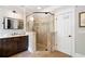 Bathroom with tiled glass enclosed shower, marble countertop vanity, and decorative mirror at 4675 Lakeway Pl, Alpharetta, GA 30005