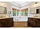 Bright bathroom features a soaking tub with mosaic accents and dual dark-stained vanities at 4675 Lakeway Pl, Alpharetta, GA 30005
