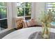 Close up of window seating in dining nook with decorative pillows, hardwood floors and a wooden table centerpiece at 4675 Lakeway Pl, Alpharetta, GA 30005